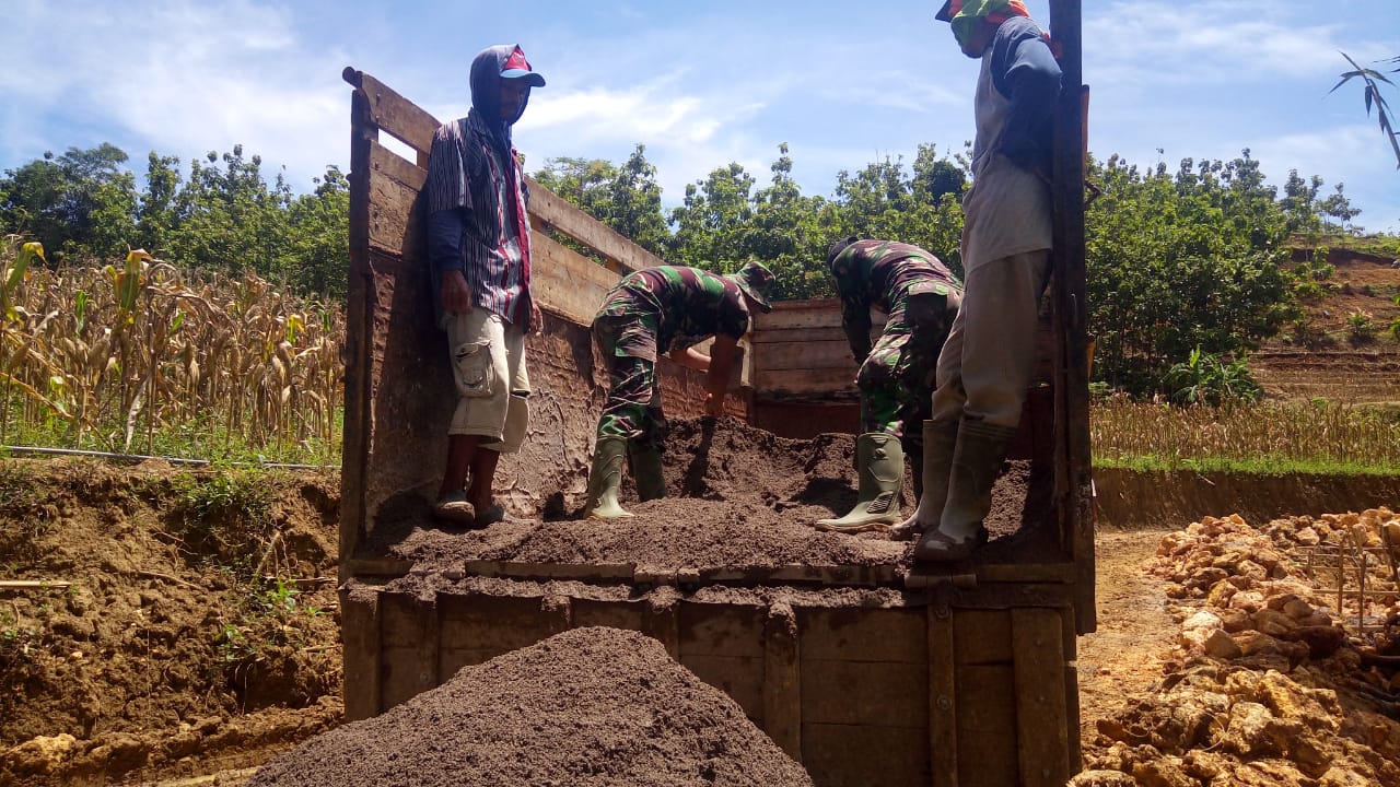 Anggota Satgas TMMD Turunkan Pasir Secara Manual