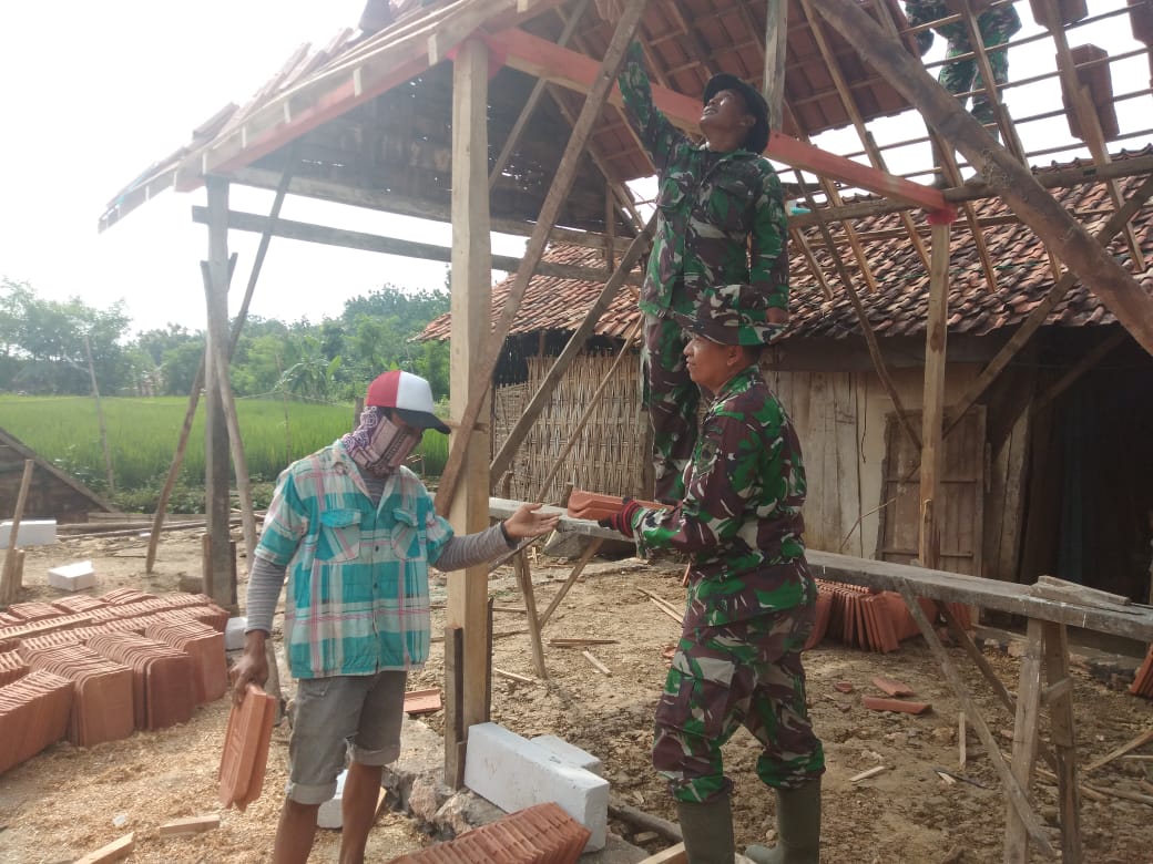 Prajurit mulai memasang genteng rumah Sutiyono