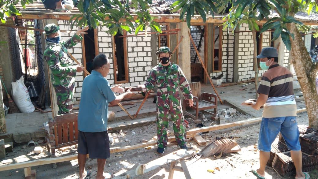 TNI  Bersama Warga Naikkan Genteng Rumah Sukandar