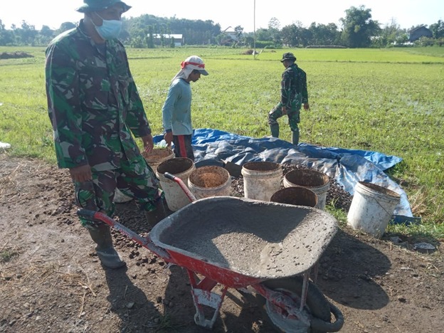 Anggota Satgas TMMD Reg 111 Mengantri Adonan Cor Untuk Dilangsir