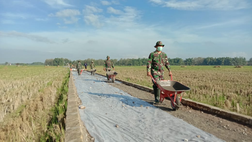 Semangat Satgas TMMD Terlihat Saat Mengoperasikan Alat Dorong Angkong