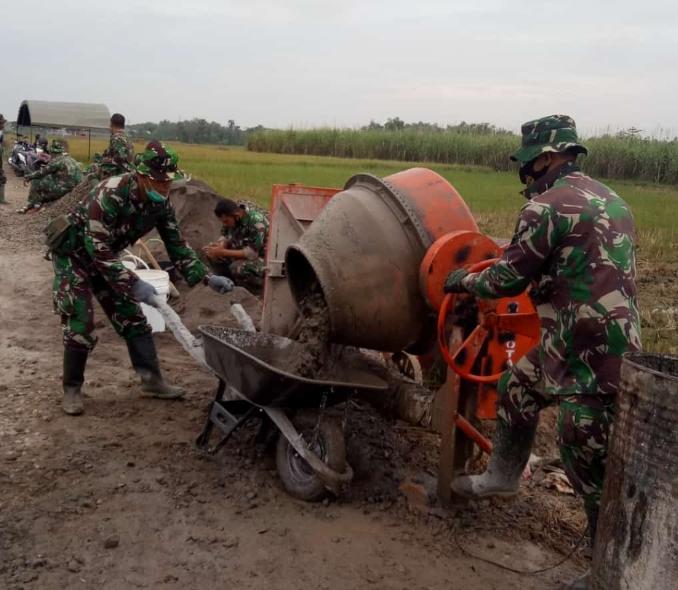 Bagaikan Membuat Adonan Kue, Anggota Satgas TMMD Operasionalkan Mesin Molen