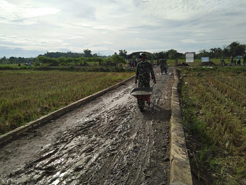 Semangat Satgas TMMD Dengan Gerobak Dorong Rangka Pengecoran Jalan