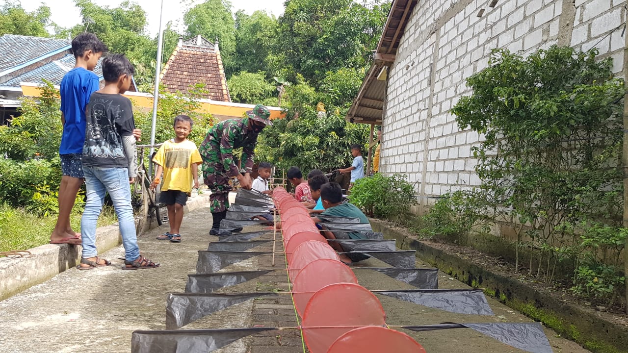 Satgas TMMD Bantu Anak-anak Buat Layang-layang Naga