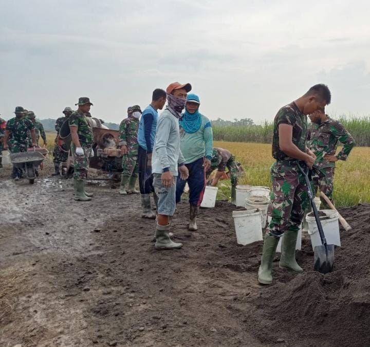 Cangkul dan Ember Personil Tim Satgas Siap Siaga Angkut pasir Demi Kelancaran Kegiatan TMMD