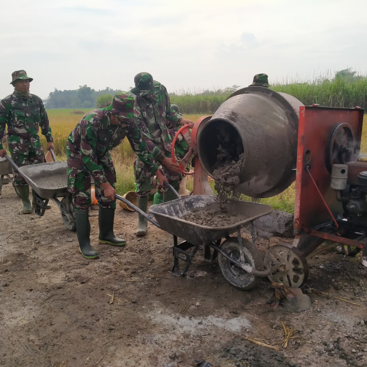 Anggota Satgas TMMD Hati-hati Tuang Adukan Beton Ke Angkong