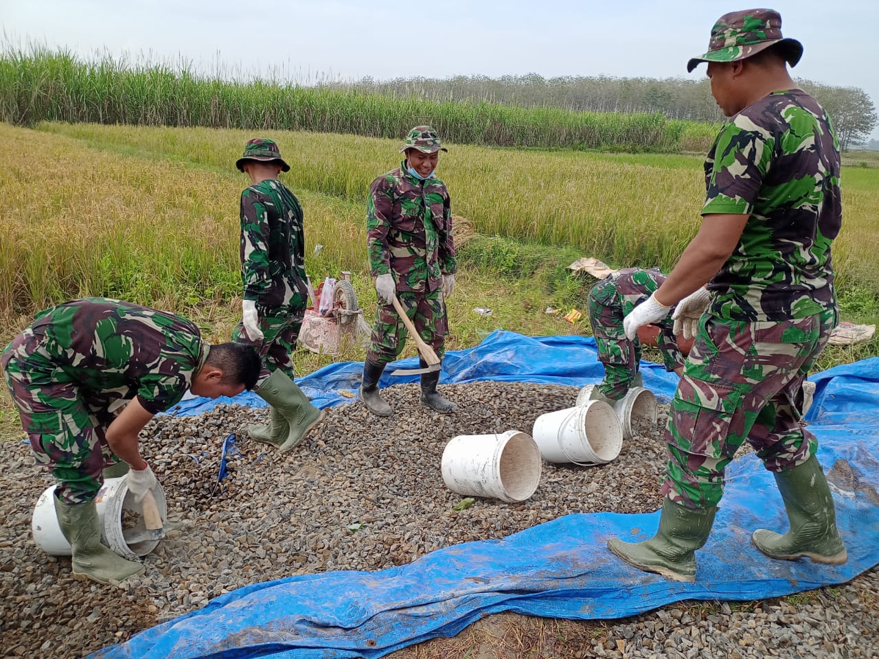 Anggota Satgas TMMD Berjibaku Angkut Material Untuk Adukan Betonisasi Jalan Desa Tamansari