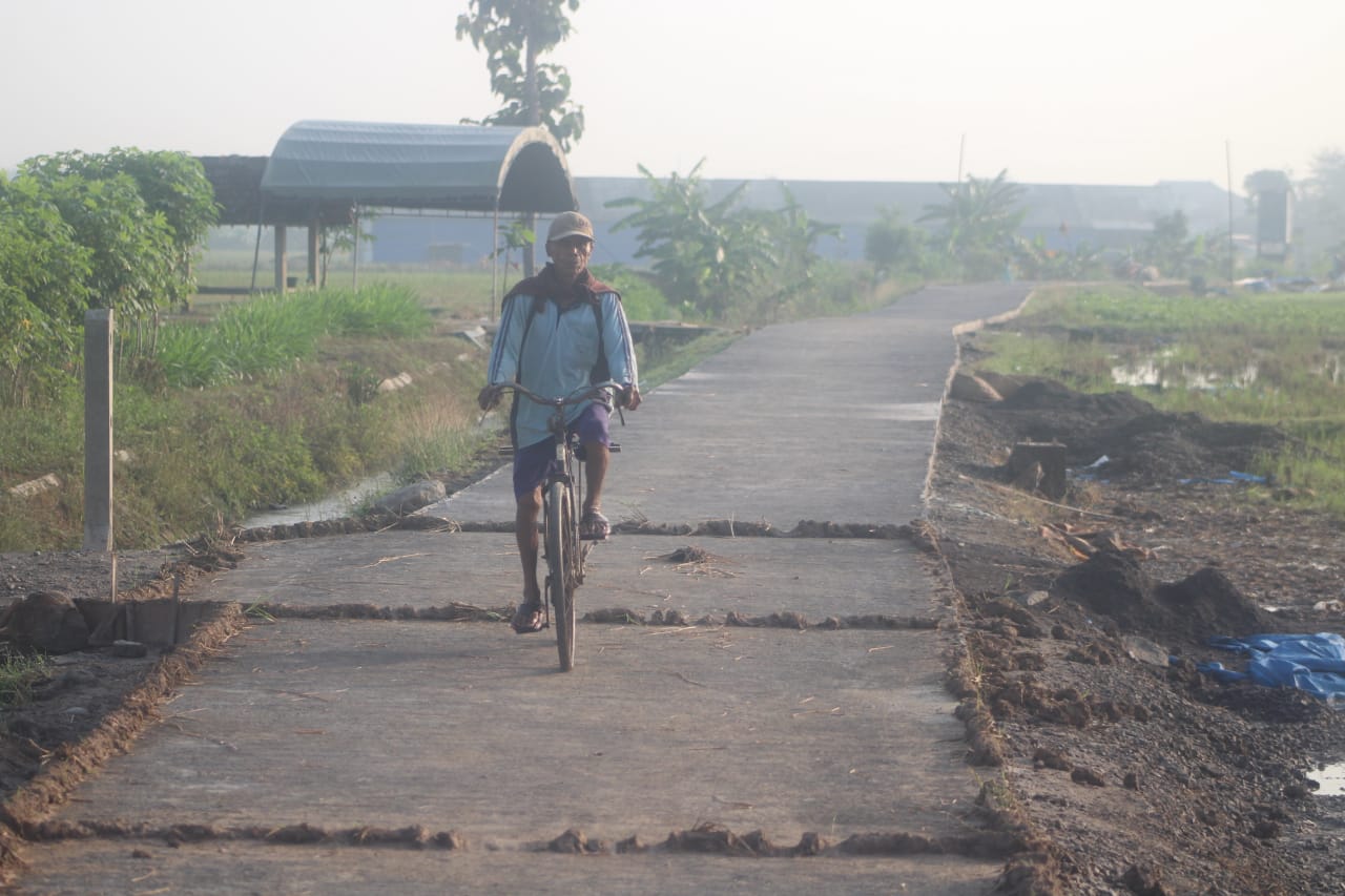 Sangat Menikmati Perjalanan, Terlihat Satu Warga Melintas Di Jalan Yang Baru Dibangun Sangat Menikmati Perjalanan, Terlihat Satu Warga Melintas Di Jalan Yang Baru Dibangun