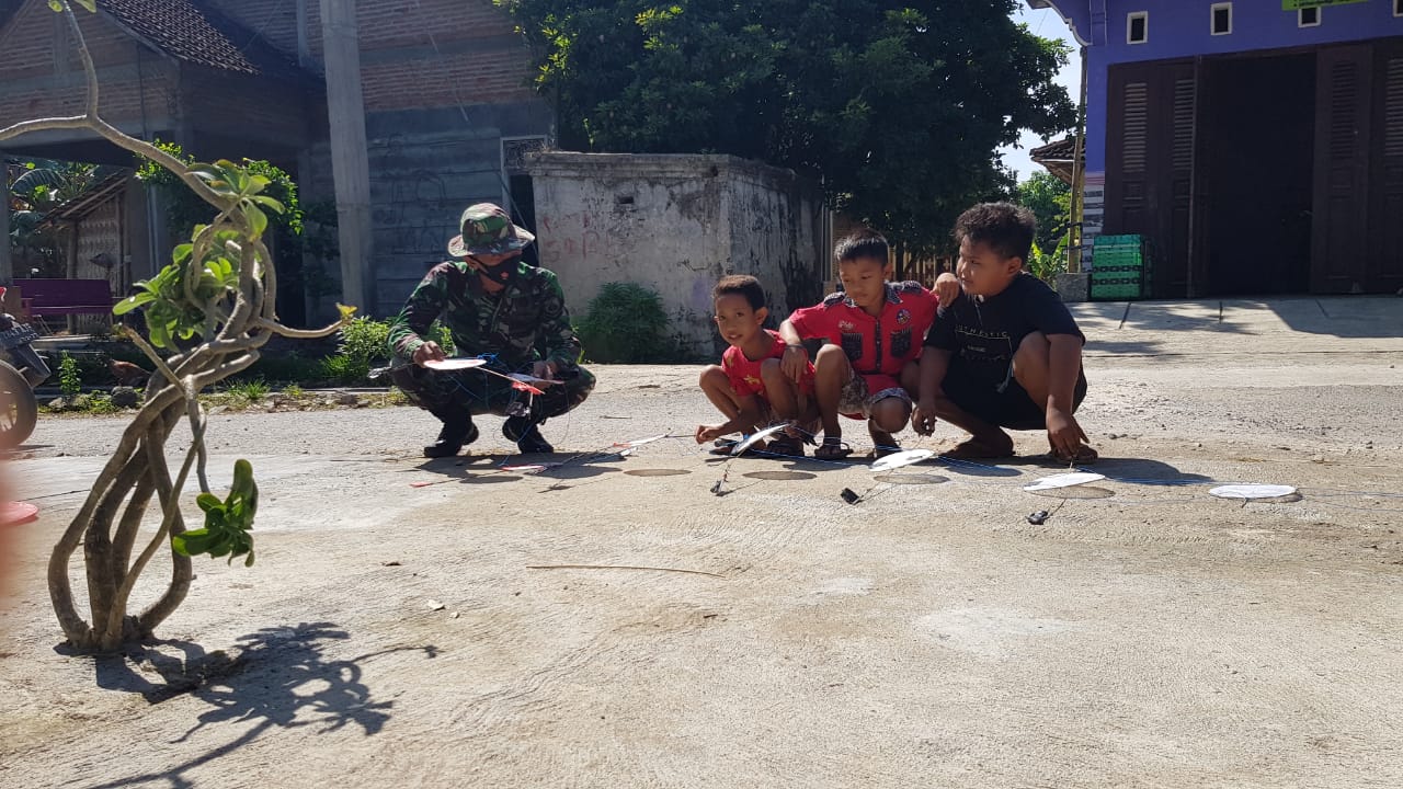 Kedekatan Anak-anak Desa Tamansari Dan Satgas TMMD Saat Bermain Layang-layang