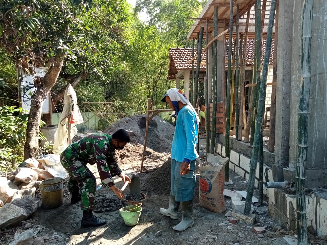 Sertu Sumarno Mahir Menggunakan Cangkul Mengaduk Pasir Semen di Rehab RTLH