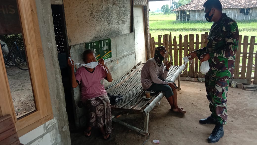 Sertu Sumarno Bagikan Masker Ke Warga Masyarakat Lokasi TMMD Reguler Ke-111