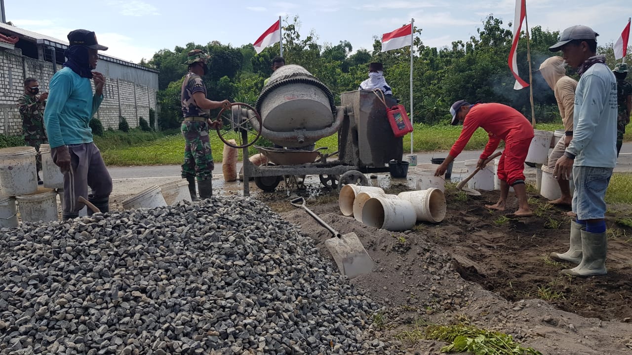 Satgas TMMD Dan Masyarakat Memindahkan Sisa Agregat Pekerjaan Pengecoran