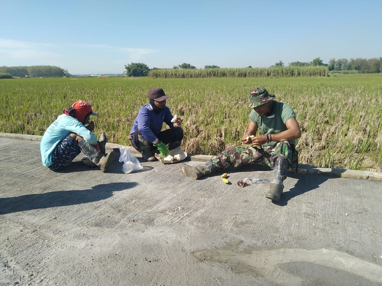 Anggota TMMD Dan Warga Menghilangkan Lelah Istirahat Di Pinggir Jalan